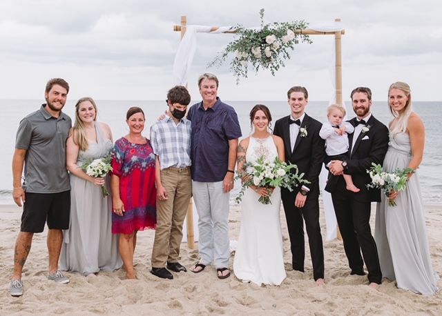 Thomas with his family at a wedding on the beach.