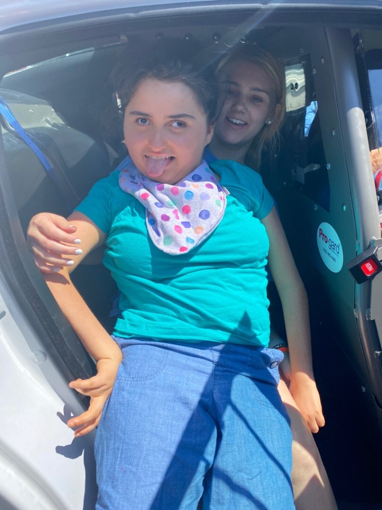 Cailyn in the back of police car during a special day at summer camp.