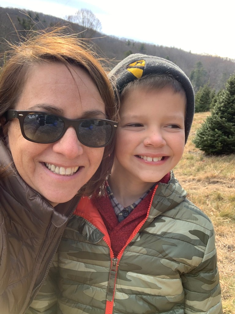 Selfie of a mother and her son outside, both smiling.